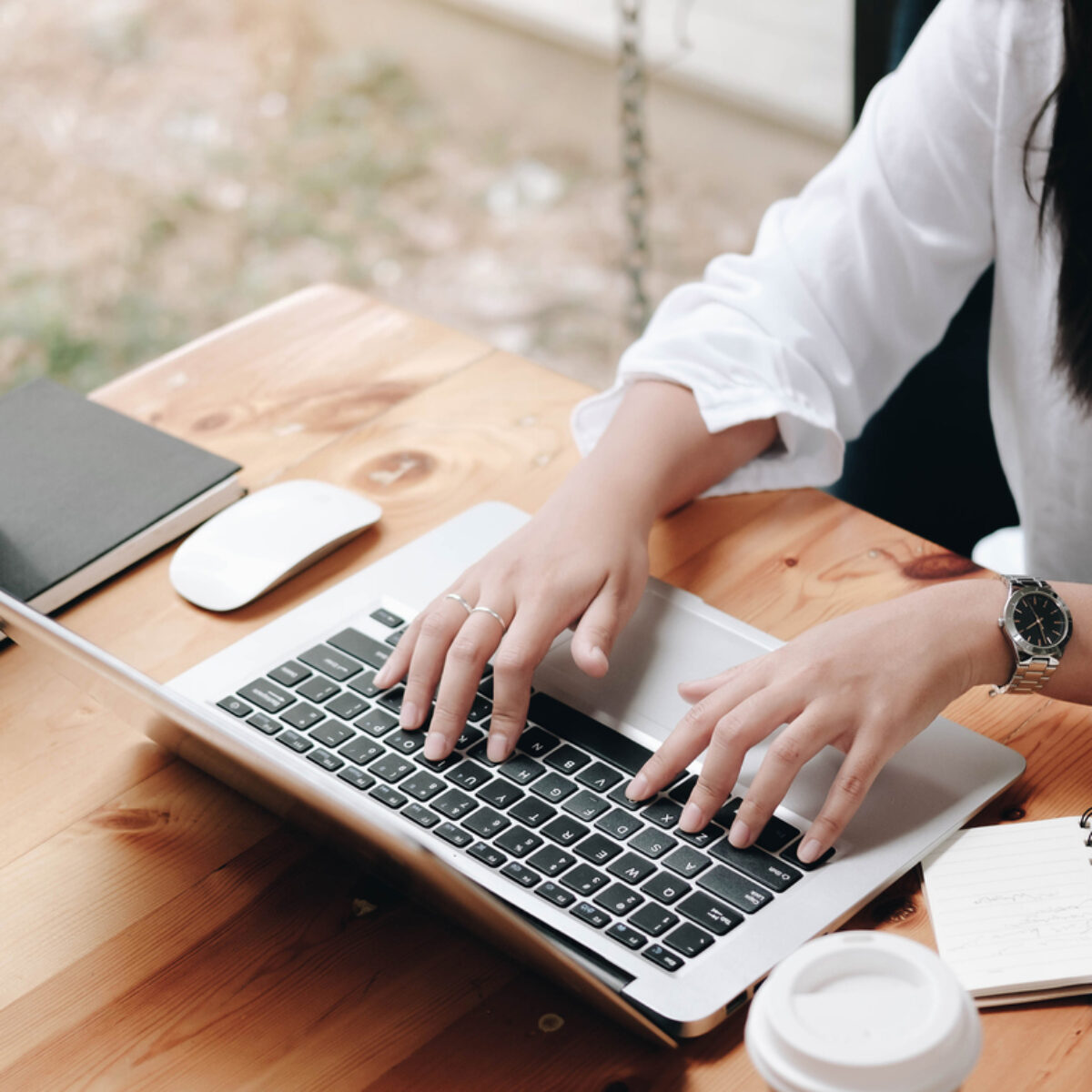 A woman at a desk typing on a laptop.