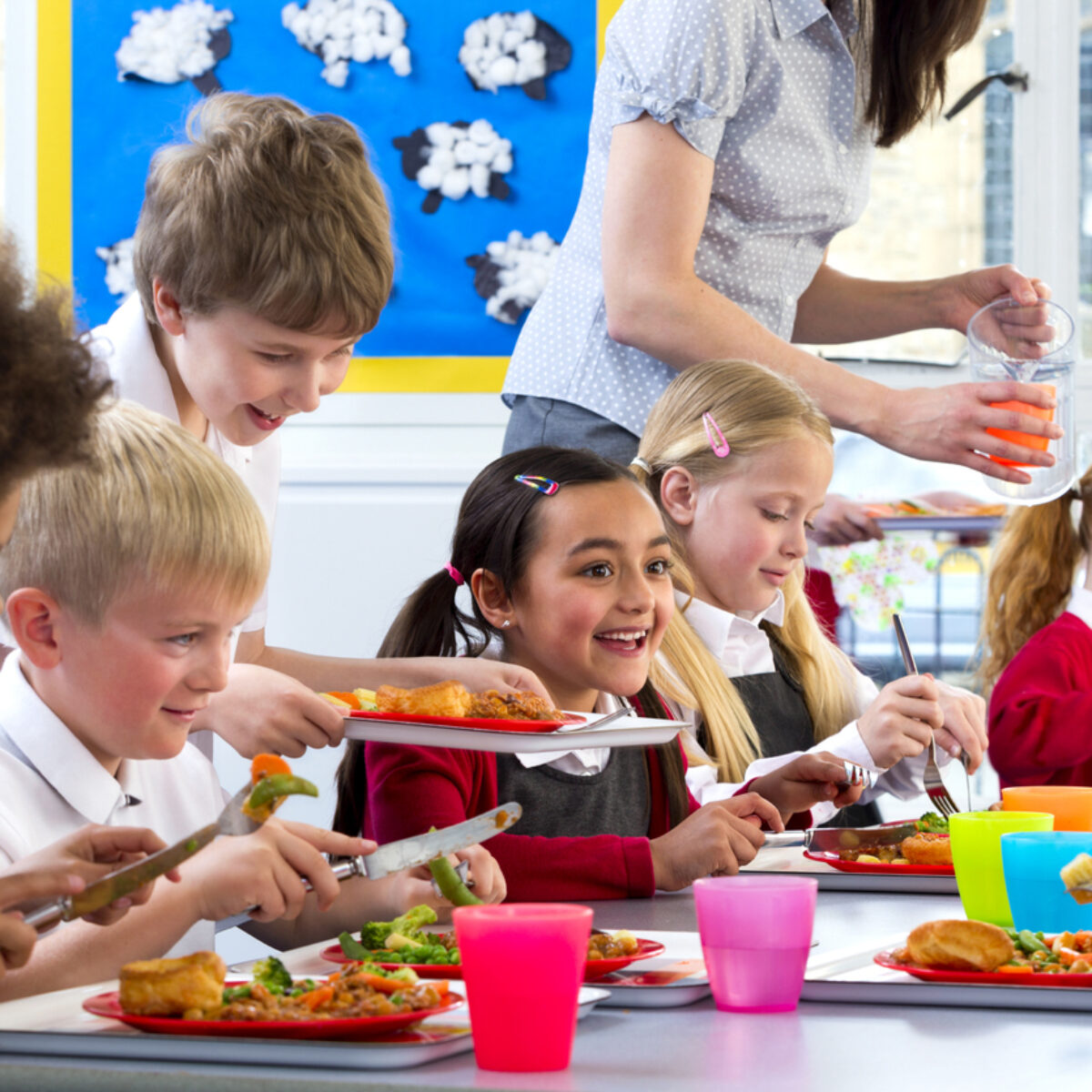 Happy school children enjoying their school dinners