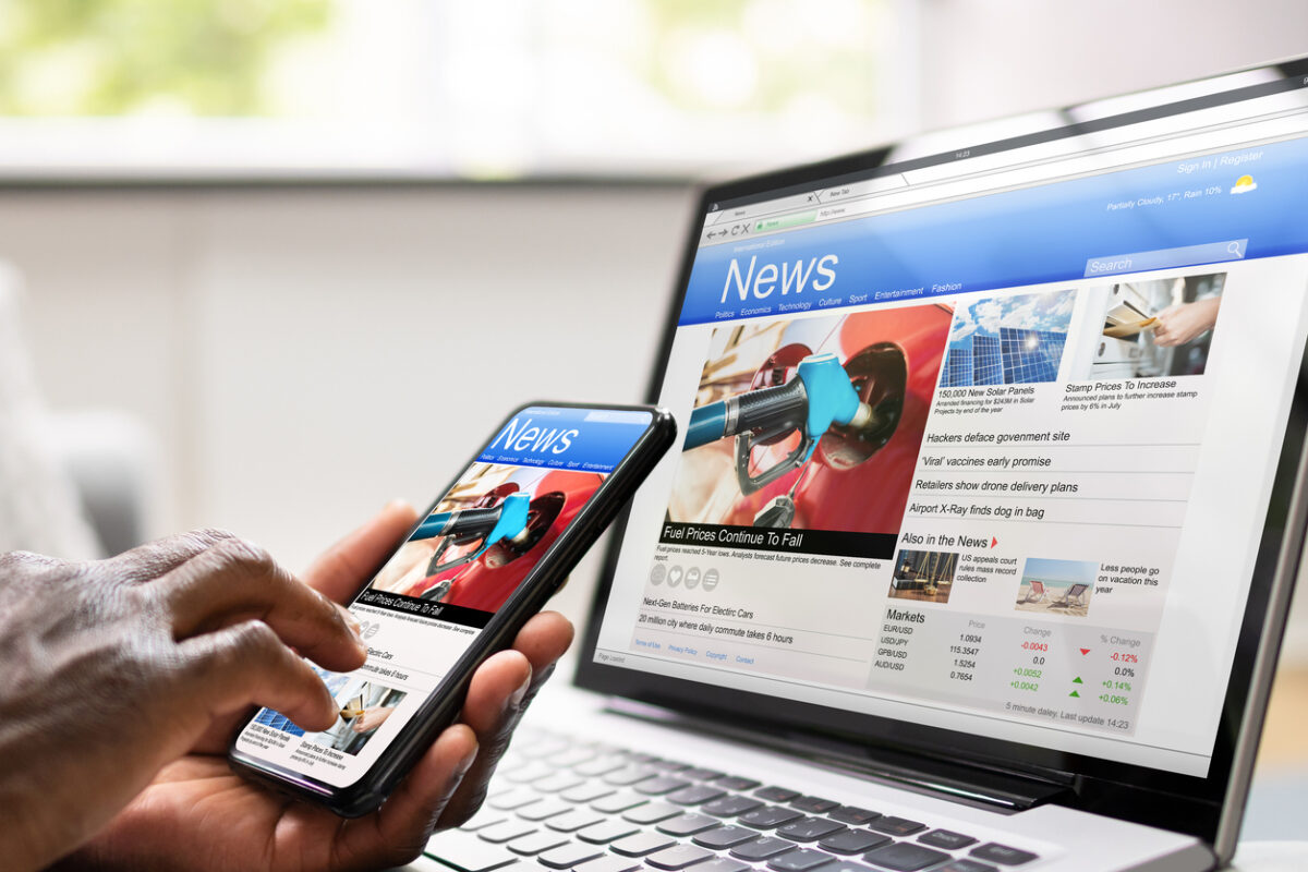 A laptop and mobile phone with a news website open on each screen